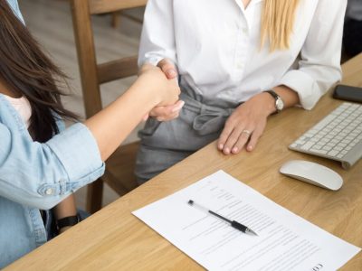 two-women-partners-handshaking-after-signing-business-contract-meeting_1163-4924